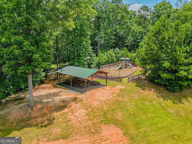 view of yard featuring a carport, a playground, and fence