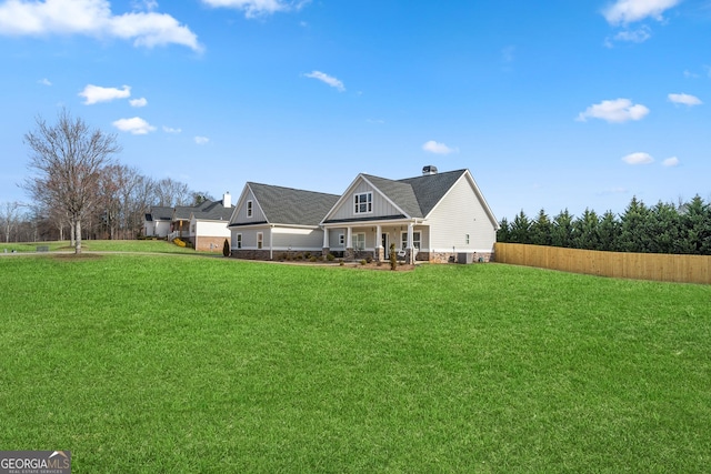 view of front of home with fence, a porch, board and batten siding, and a front yard