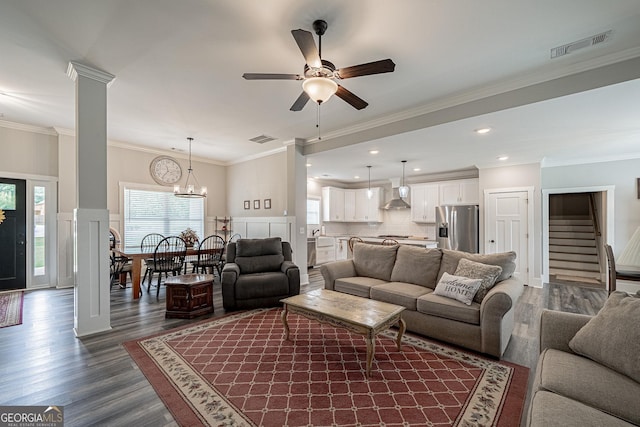 living area with dark wood finished floors, visible vents, and ornate columns