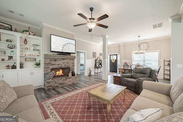 living area featuring a wainscoted wall, visible vents, a fireplace, and decorative columns