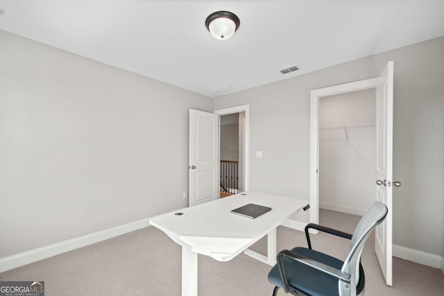 home office with light colored carpet, visible vents, and baseboards