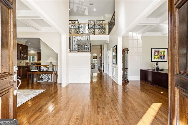 foyer with beamed ceiling, coffered ceiling, and hardwood / wood-style floors