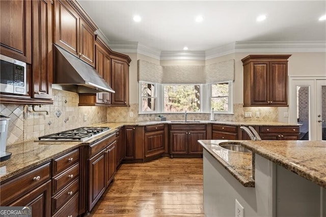 kitchen with appliances with stainless steel finishes, sink, and light stone counters