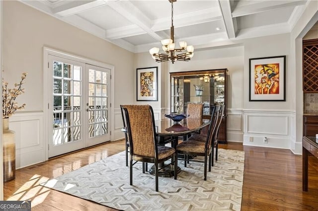 dining area featuring french doors, light hardwood / wood-style flooring, beam ceiling, a notable chandelier, and coffered ceiling