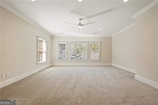 carpeted empty room with ceiling fan, ornamental molding, and a wealth of natural light