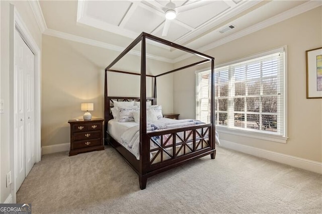 carpeted bedroom featuring a closet, crown molding, and ceiling fan