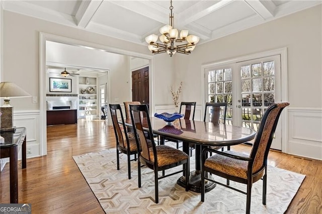 dining room with built in features, french doors, light hardwood / wood-style floors, and beam ceiling