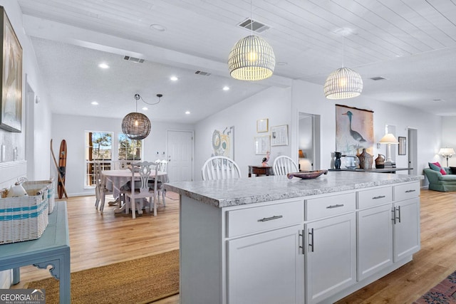 kitchen featuring light wood finished floors, visible vents, and decorative light fixtures