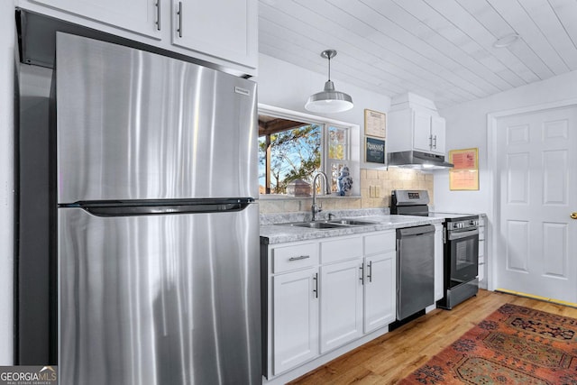 kitchen with under cabinet range hood, white cabinetry, stainless steel appliances, and a sink