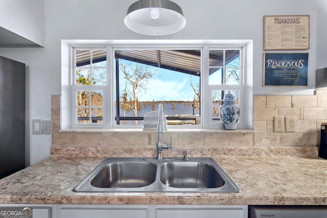 kitchen with dishwasher, light countertops, a sink, and white cabinets