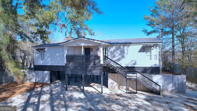 view of front of home with metal roof and stairway