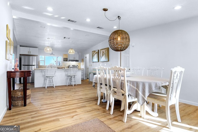 dining space with lofted ceiling, light wood finished floors, visible vents, and recessed lighting