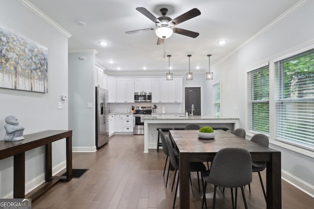 dining area with dark hardwood / wood-style flooring, ceiling fan, and crown molding