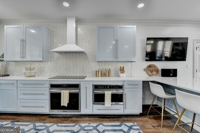 kitchen with ornamental molding, wall chimney exhaust hood, oven, and black electric cooktop