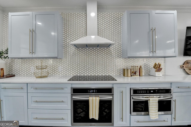 kitchen with light countertops, wall chimney exhaust hood, oven, and black electric stovetop