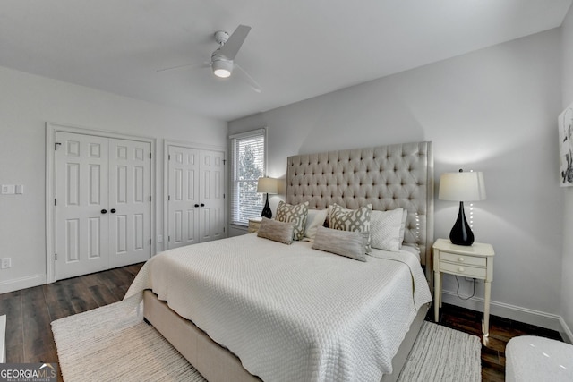 bedroom with two closets, baseboards, a ceiling fan, and wood finished floors
