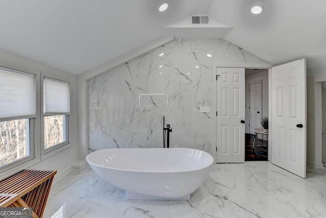 full bath with a freestanding bath, visible vents, recessed lighting, lofted ceiling, and marble finish floor