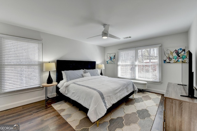 bedroom with ceiling fan, baseboards, wood finished floors, and visible vents
