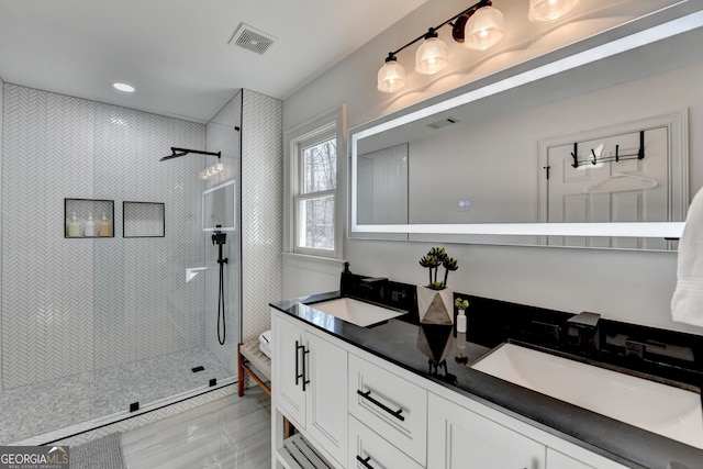 full bath with walk in shower, visible vents, and a sink