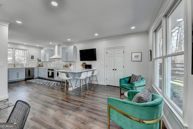 interior space with plenty of natural light, recessed lighting, ornamental molding, and dark wood finished floors