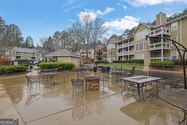 view of property's community featuring an outdoor fire pit and a patio