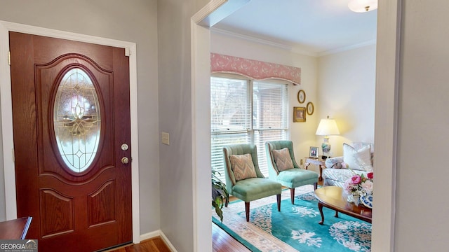 entrance foyer with hardwood / wood-style floors and crown molding