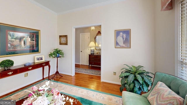 sitting room with hardwood / wood-style flooring and crown molding