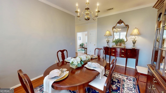 dining area featuring wood-type flooring, a notable chandelier, and ornamental molding