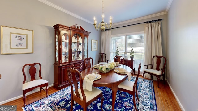 dining space featuring hardwood / wood-style flooring, ornamental molding, and an inviting chandelier