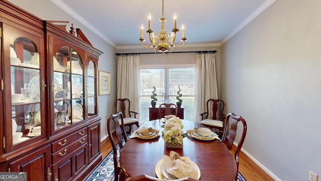 dining room featuring a chandelier, light hardwood / wood-style flooring, and ornamental molding