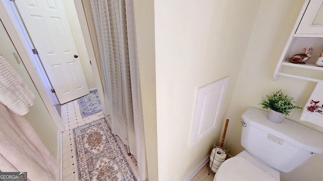 bathroom with toilet and tile patterned flooring