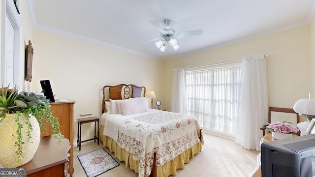 carpeted bedroom featuring ceiling fan and crown molding