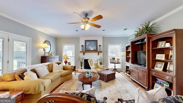 living room featuring a brick fireplace, ceiling fan, crown molding, and hardwood / wood-style floors