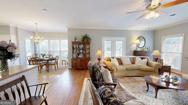 living room featuring light wood-type flooring, crown molding, and a healthy amount of sunlight