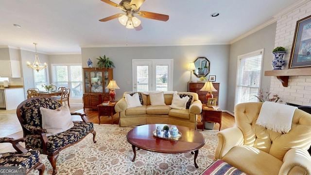 living room with ceiling fan with notable chandelier, light hardwood / wood-style floors, and crown molding