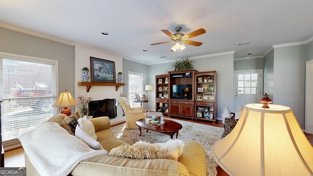 living room with ceiling fan, wood-type flooring, ornamental molding, and a fireplace