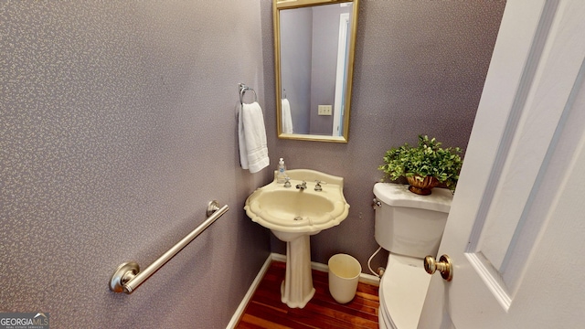 bathroom with toilet and wood-type flooring