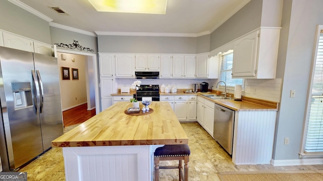 kitchen featuring stainless steel appliances, a kitchen island, sink, white cabinets, and wooden counters