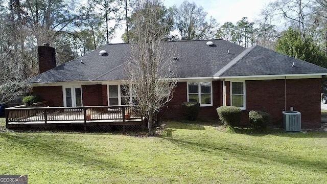 rear view of property featuring a deck, central AC unit, and a yard