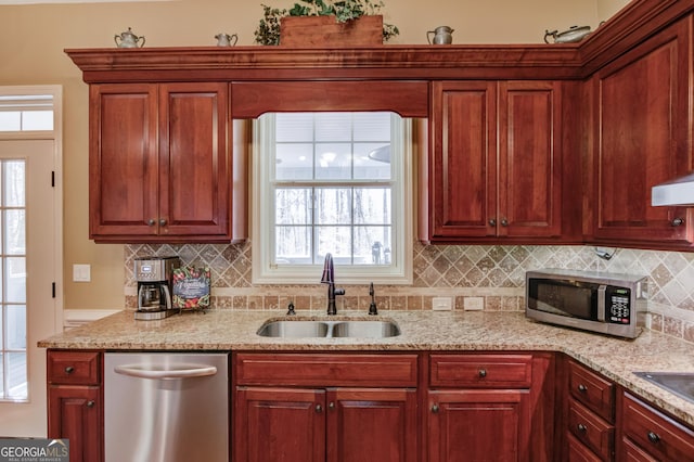 kitchen featuring stainless steel appliances, reddish brown cabinets, and a sink