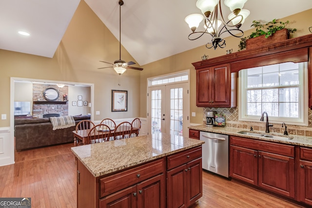 kitchen featuring dishwasher, decorative light fixtures, a sink, and a center island