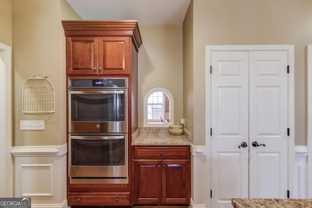 kitchen with double oven and light stone counters