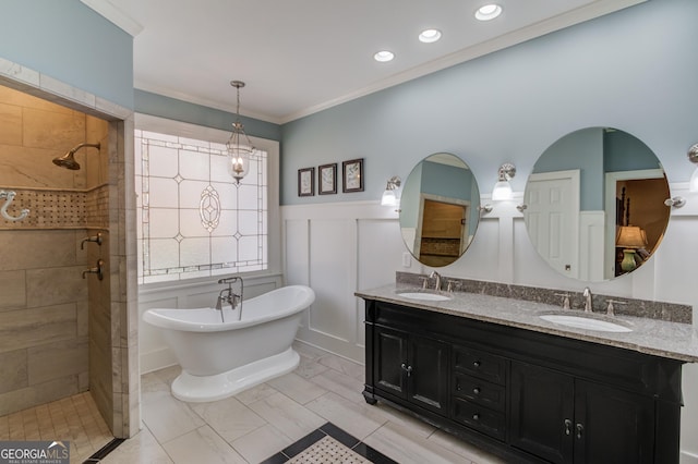 bathroom featuring crown molding, a soaking tub, a wainscoted wall, and a sink