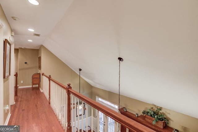 hallway with vaulted ceiling, baseboards, wood finished floors, and recessed lighting