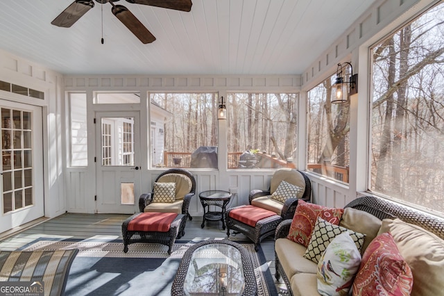 sunroom with a ceiling fan and wooden ceiling