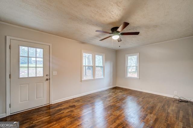 interior space featuring crown molding, a textured ceiling, baseboards, and wood finished floors