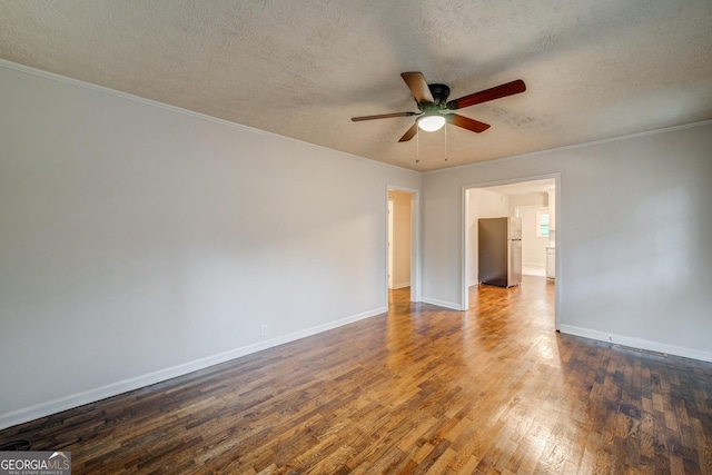 unfurnished room with dark wood-style flooring, crown molding, ceiling fan, a textured ceiling, and baseboards