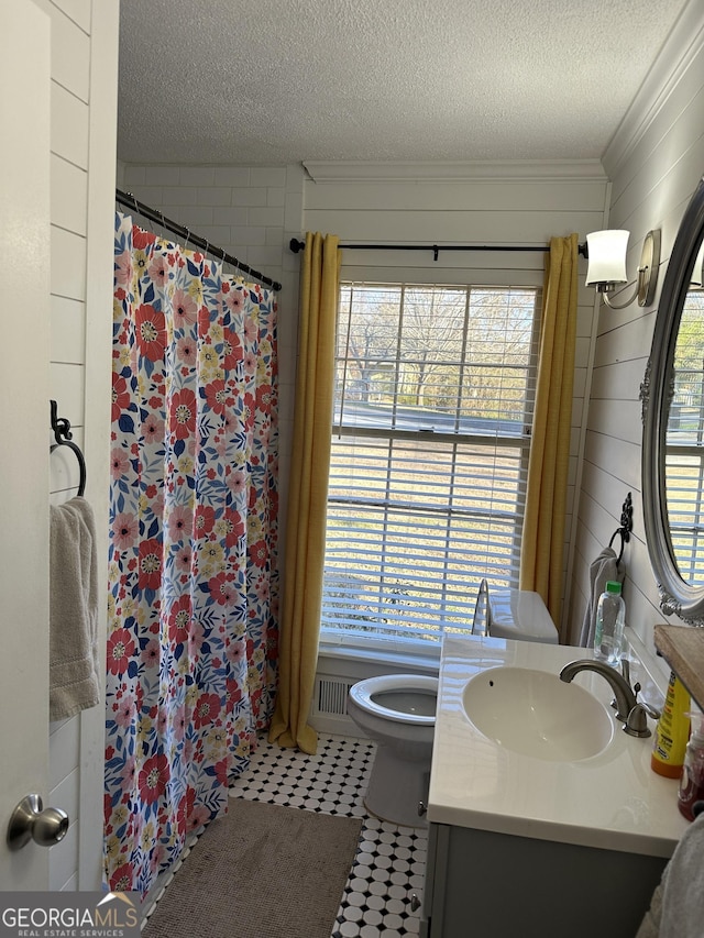 bathroom with toilet, a textured ceiling, crown molding, a shower with shower curtain, and vanity