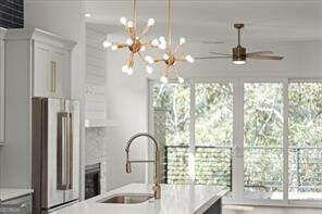 kitchen featuring sink, high end fridge, and an inviting chandelier