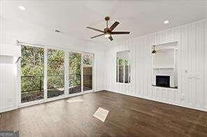 unfurnished living room with dark hardwood / wood-style flooring and ceiling fan